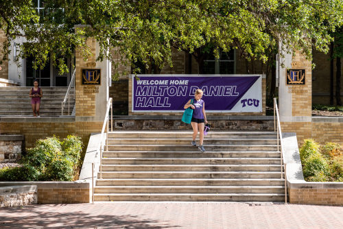 Student walking down the stairs in front of Milton Daniel