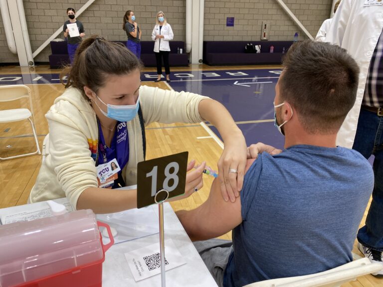 TCU nursing student administers flu vaccine.