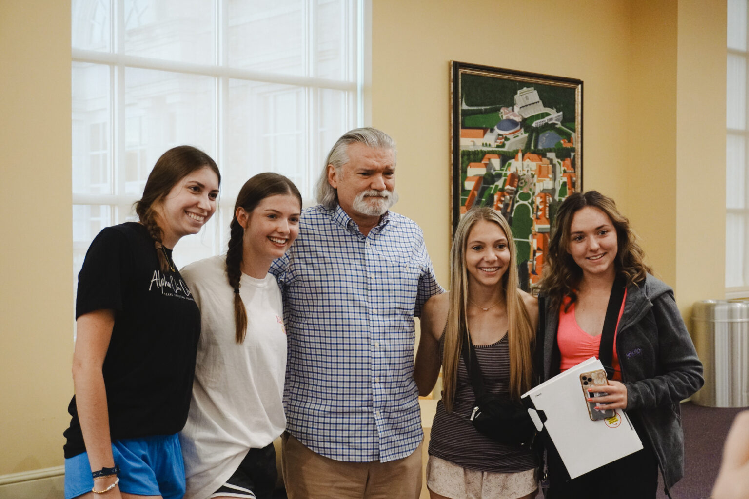 Four students gather around Eduardo Salas for a photo