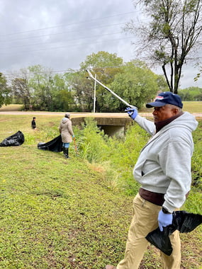 TCU Staff member holding trash picker