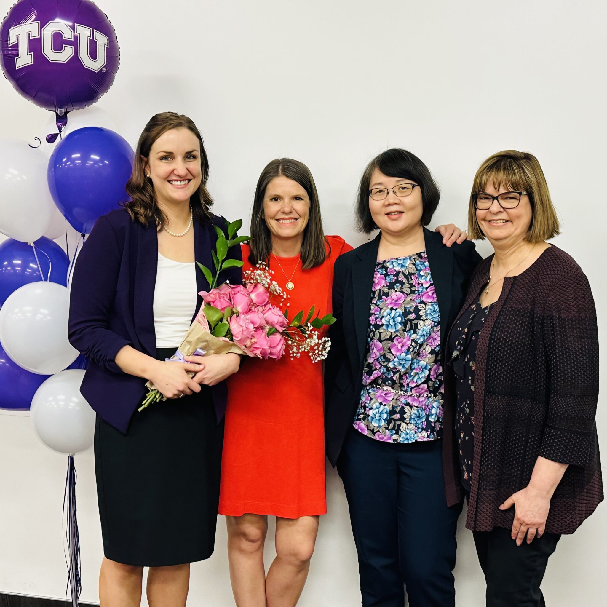 Diana holding a flower bouquet with the Dissertation Committee next to her