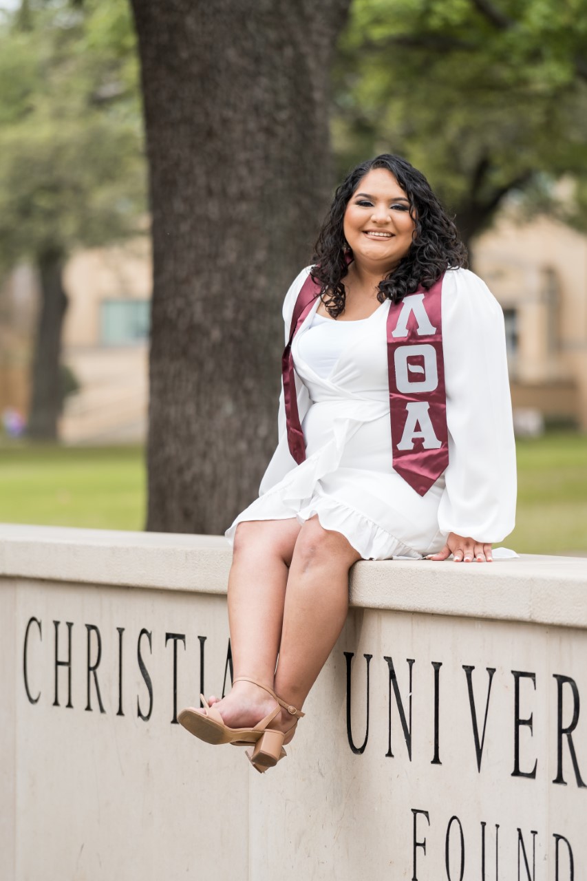 Elena Olalde senior picture on the TCU sign