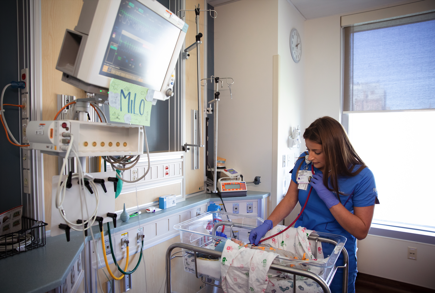 Emma Joy checking on an infant with a stethoscope