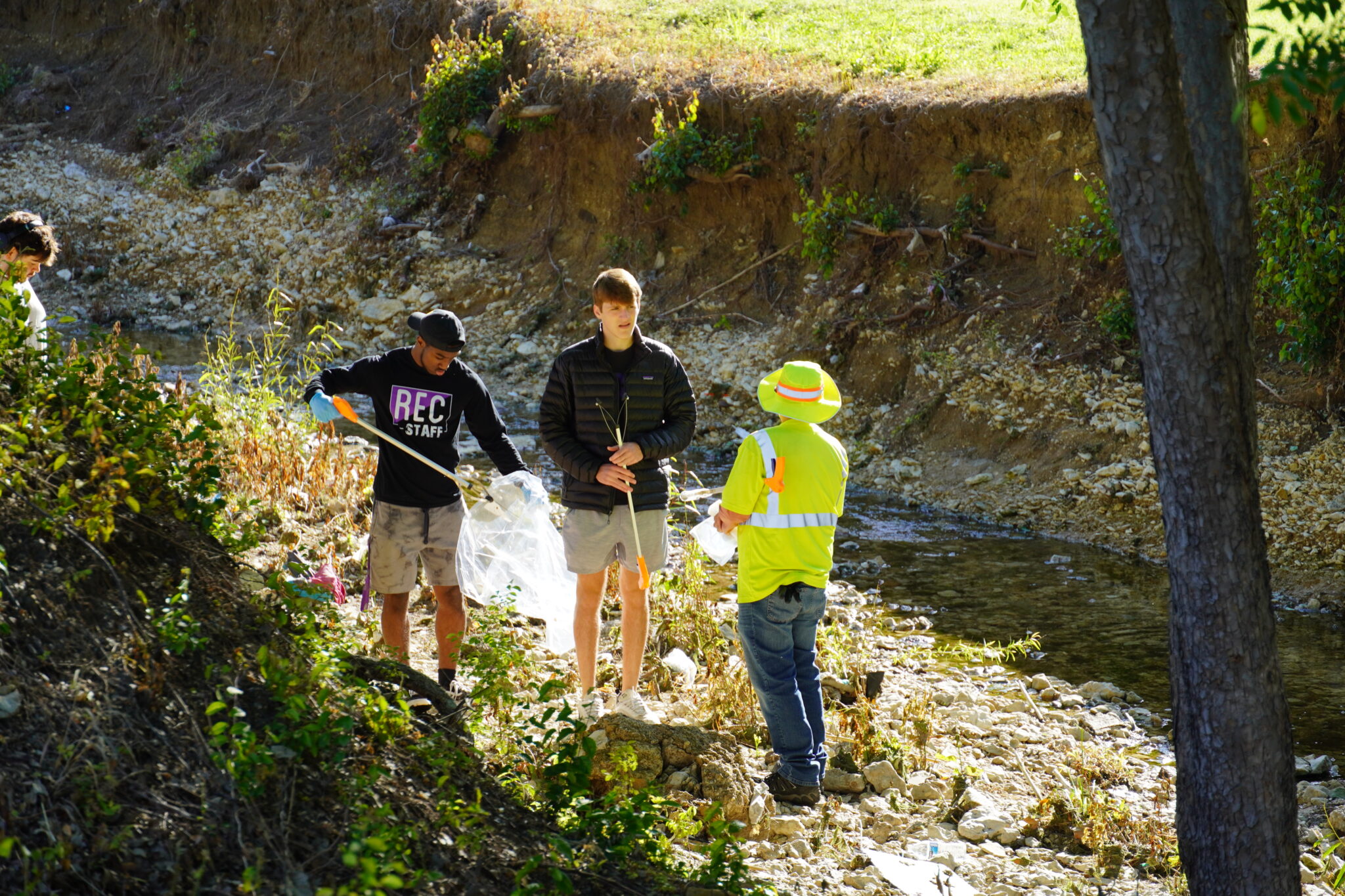 TCU community picking up trash with their respective tools and gloves