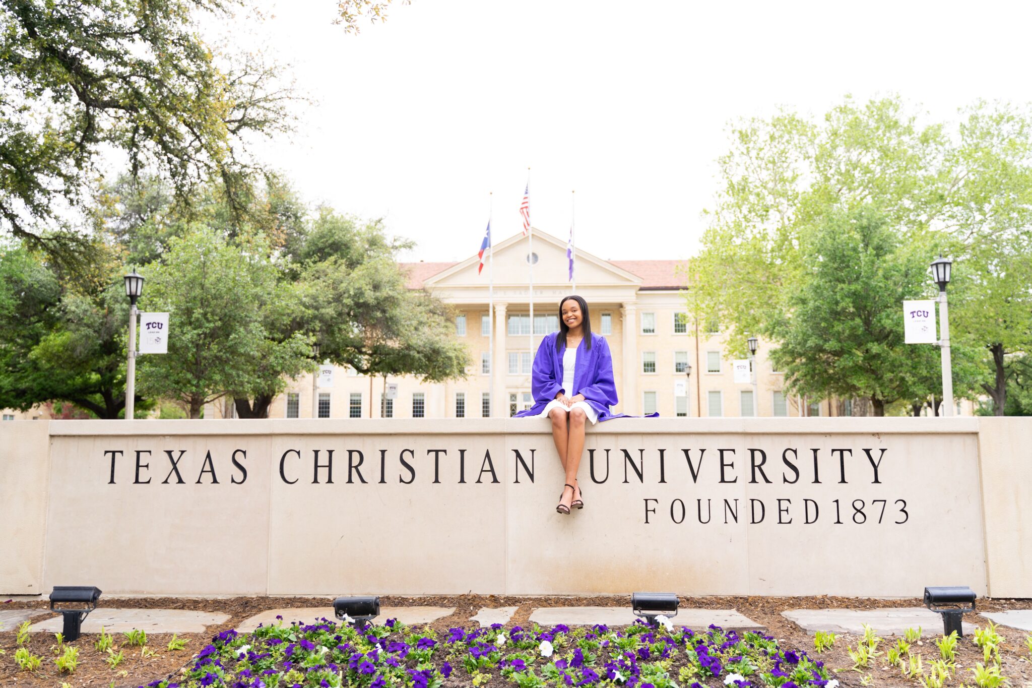 Kyndal Senior picture sitting on the TCU sign